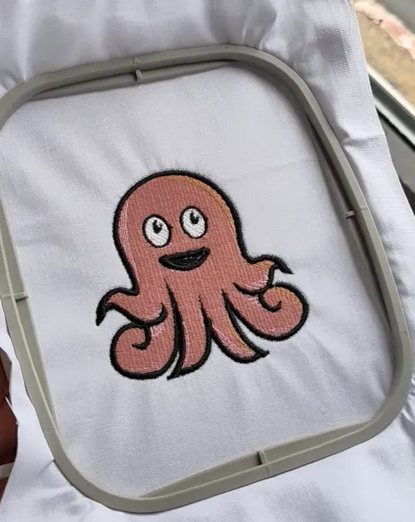 Smiling cartoon octopus stitched out in an embroidery hoop